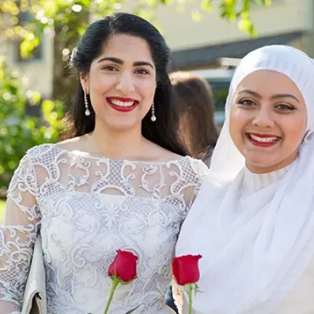 Two students holding roses on Ivy Day.